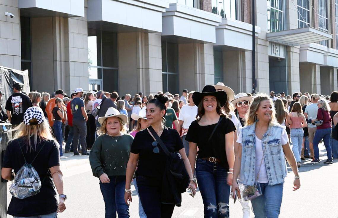 Crowds of people walk around Bank of America Stadium as they wait for Concert for Carolina tonight in Charlotte, NC on Saturday, October 26, 2024 in Charlotte, NC. All proceeds from the concert will go to Hurricane Helene relief efforts in the Carolina region.