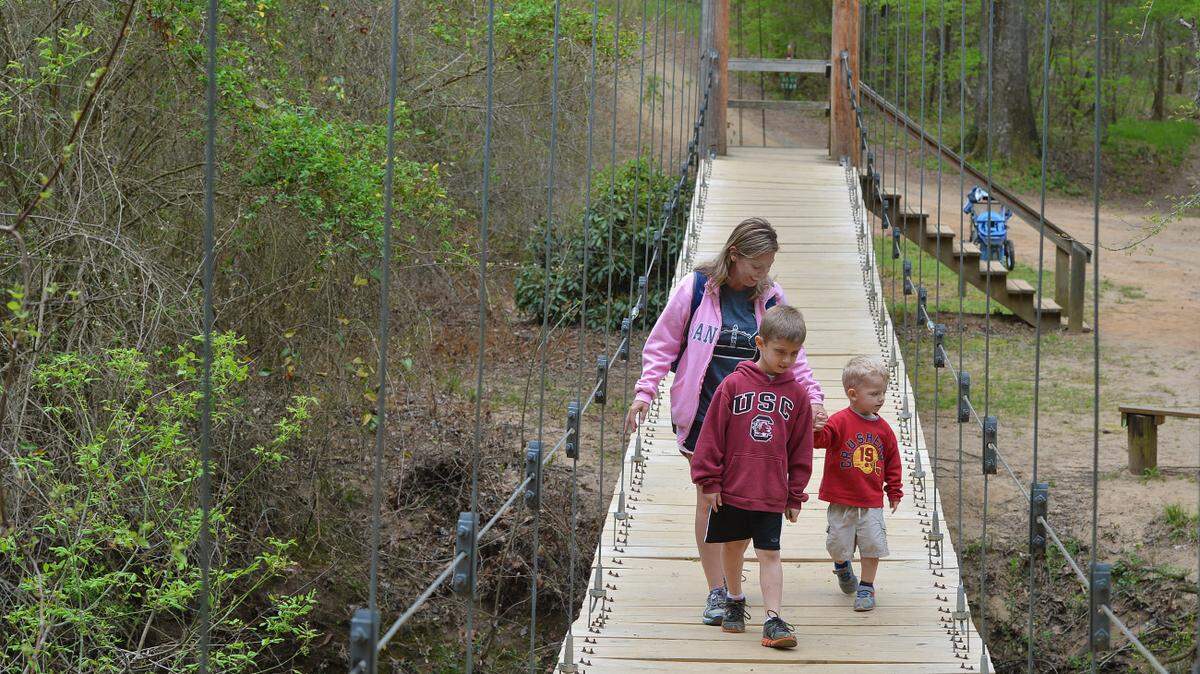 A walk over swing bridge is how people cross over Steel Creek.
Effort underway to raise money to keep Anne Close Springs Greenway going for decades to come as community green space.