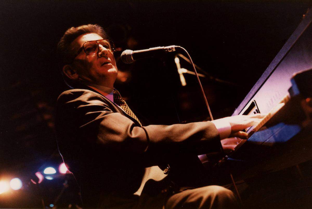 "Jerry Lee Lewis, downtown Charlotte festival, 1997. The stage was set up on Tryon Street, and was about eight inches high. No one wanted to sit too close to Jerry Lee, in case he might be in a bad mood, so I sat on the ground in front of him for much of the show." - Daniel Coston