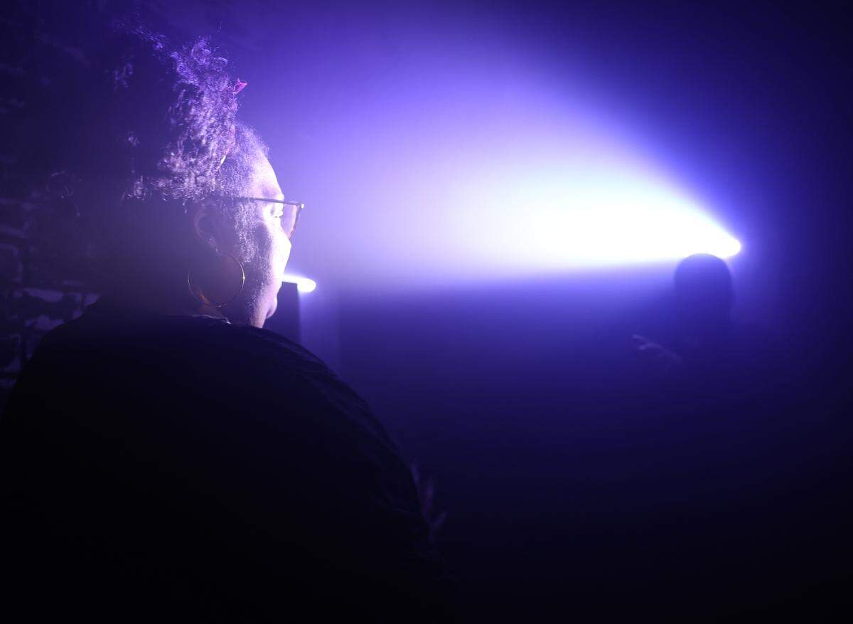Desiree Mathurin watches a priest in a spotlight at  The Conjuring: Beyond Fear experience at Scarowinds on Tuesday, Sept. 9, 2025