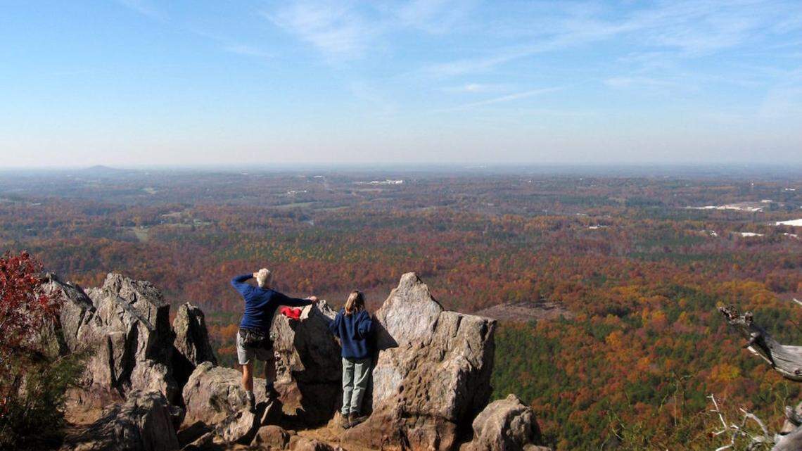 Hikers stand on the peak of Crowders Mountain overlooking the Piedmont.