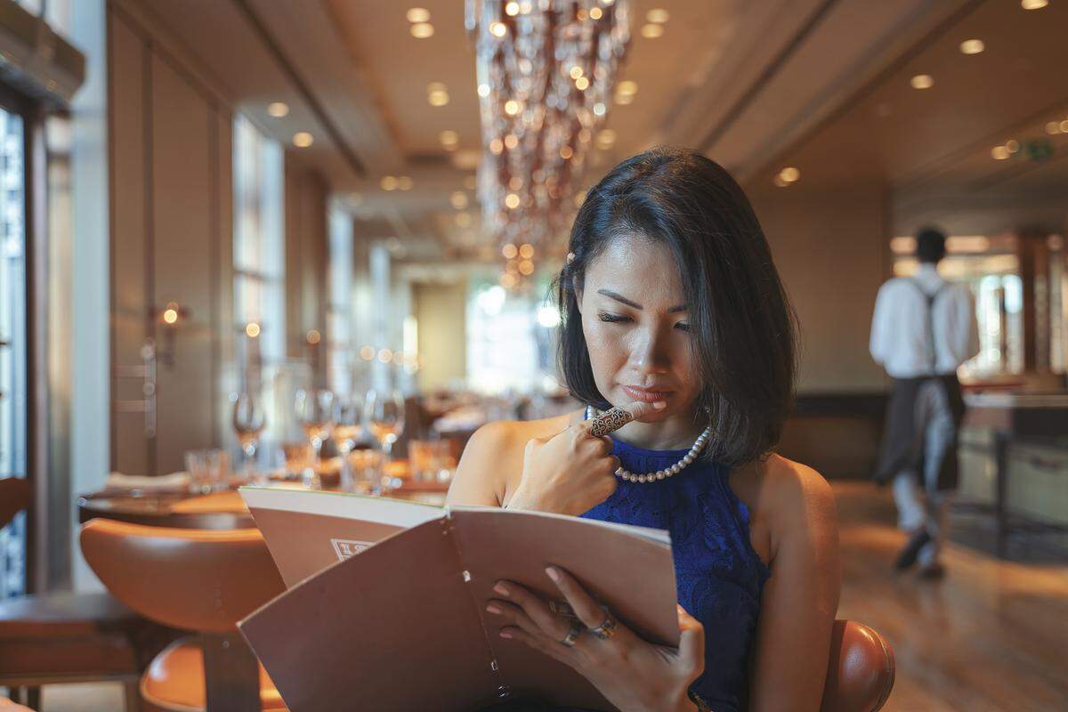 Young woman is looking at a menu in a restaurant