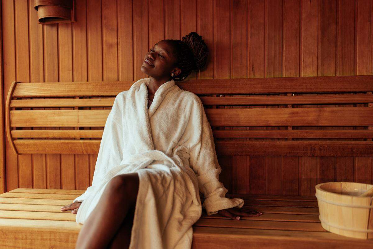 A young woman enjoying the sauna in her robe.