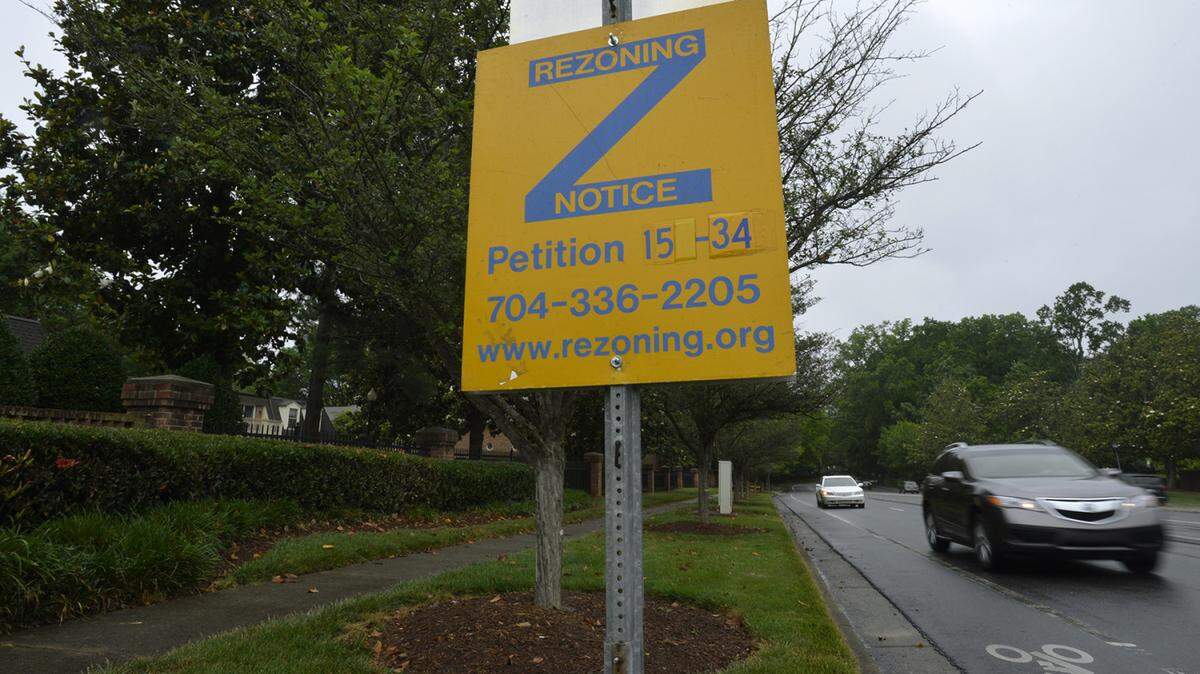A rezoning notice sign in the southwest corner of the intersection of Sharon Road and Colony Road near the Colony Apartments. The Colony apartments are set to be redeveloped in a major project that will bring more residents but has many on edge about increased density and congestion.