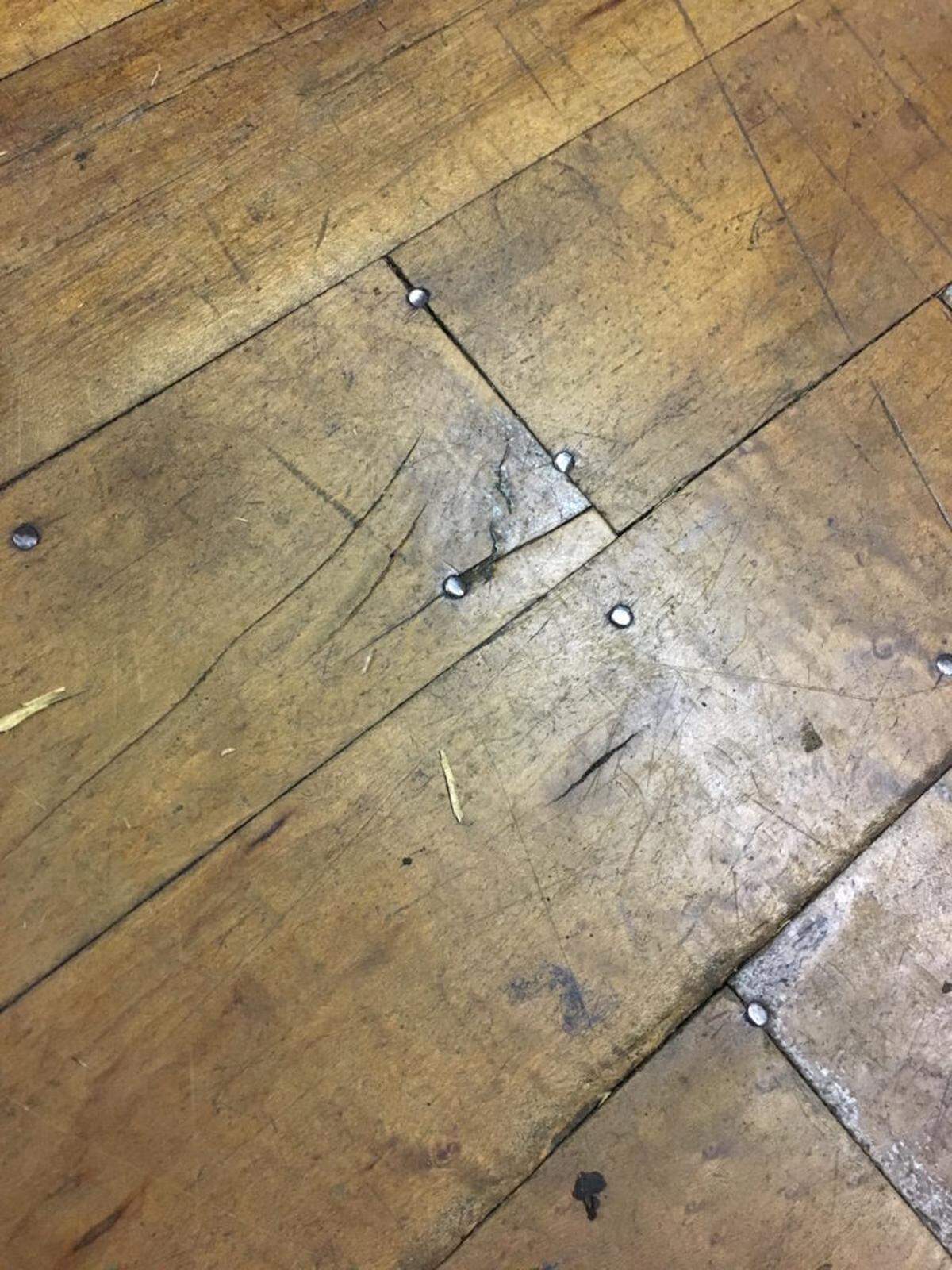 Bits of metal lodged into the hardwood floors.