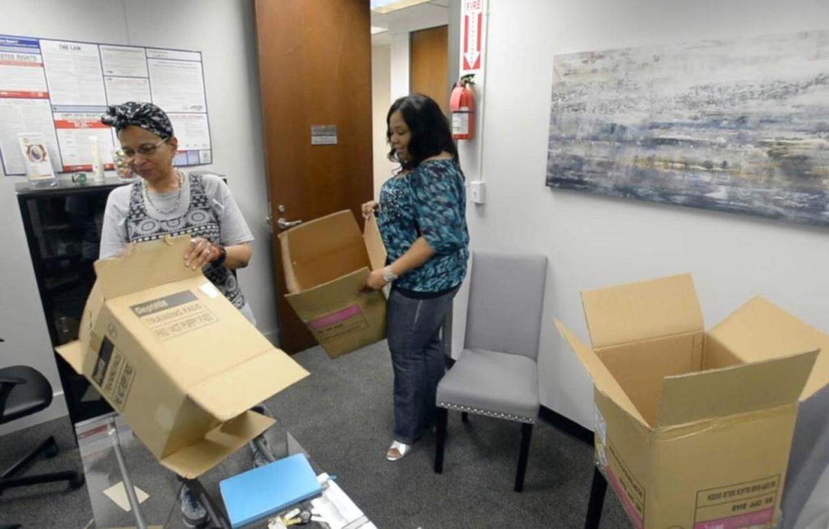 Photo by David Foster / The Charlotte Observer<br/>Community Dream Builders Communications Manager Angela Haigler, left, and Marketing and Communications Director Michelle Mattison pack up their offices in the City North Business Center along North Tryon Street in Charlotte, NC.