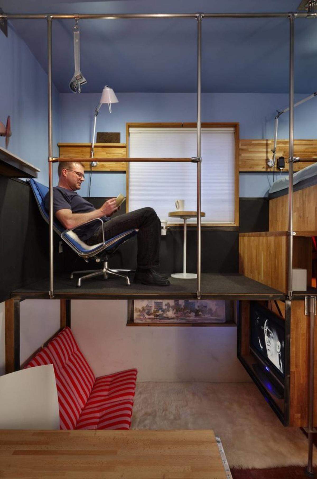 Steve Sauer relaxes in the cafe area of his 182-square-foot home in Seattle.Photo by Benjamin Benschneider MCT