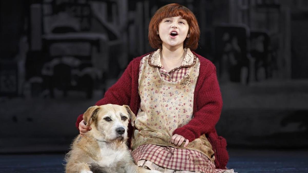 
The title character of “Annie” (Issie Swickle) comforts an equally friendless dog and names him Sandy. The show runs in Charlotte at Belk Theater July 14-19.
