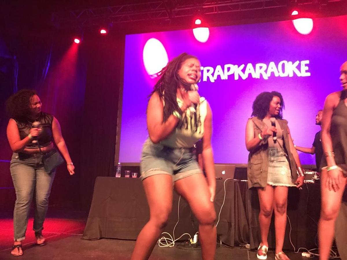 A group performing together onstage, with one friend rapping her heart out.