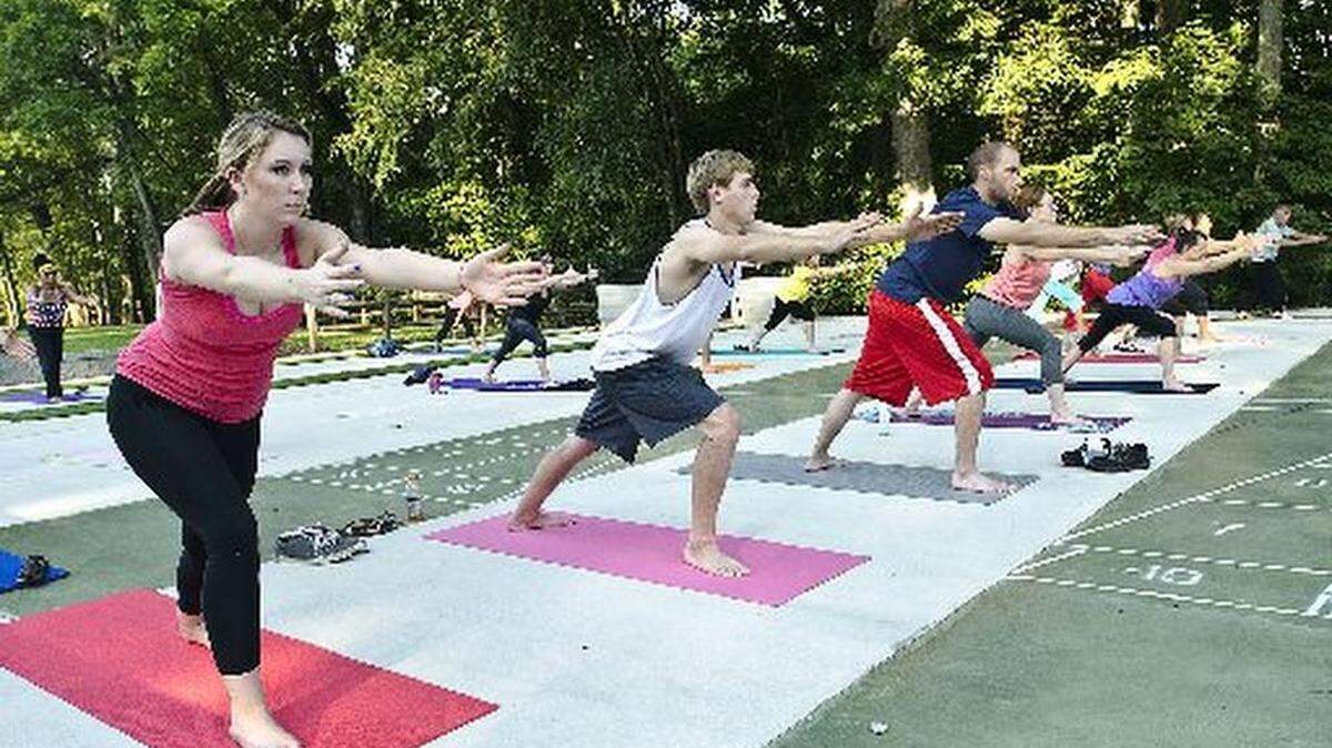 Front row, from left, Breann Causey, 19, Ryan Weatherly, 19, Mike Heitzer, 26, Hannah Kreider, 21, and Terry Feeney, 59, go through some of the moves with the group during the Yoga in the Park program at the Vietnam Veterans Park in Concord on August 26.
