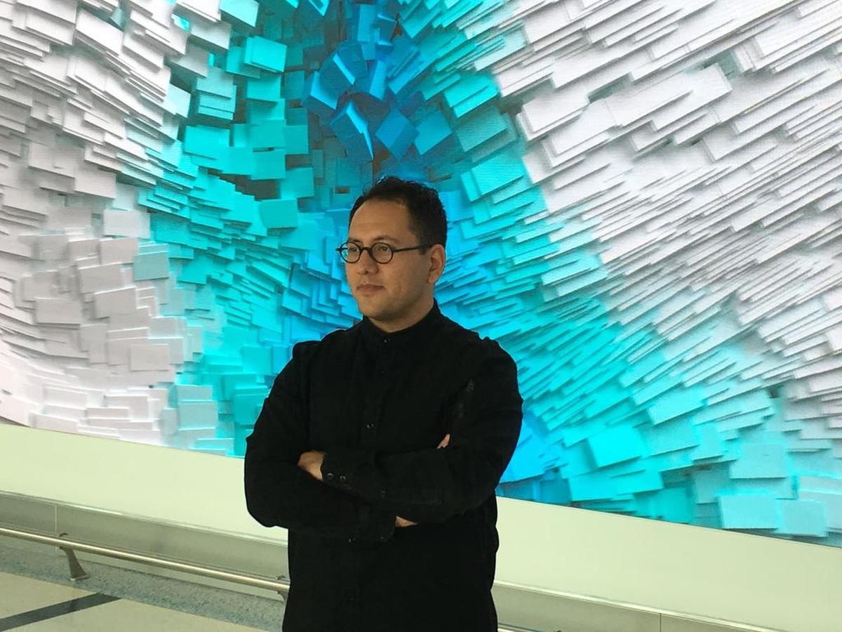 Refik Anadol in front of part of his “Interconnected” at the Charlotte airport.