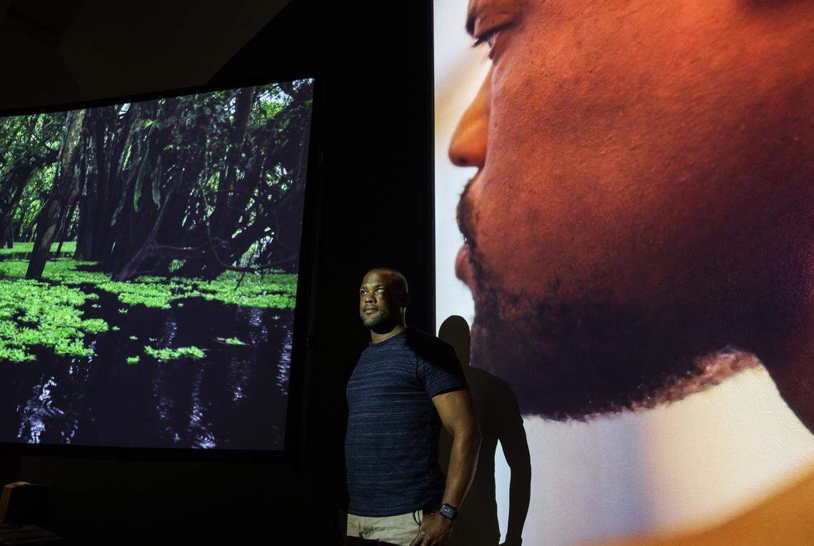 Davian Robinson, who is visually impaired, stands between two video screens at the Bechtler’s new exhibit that he collaborated on.