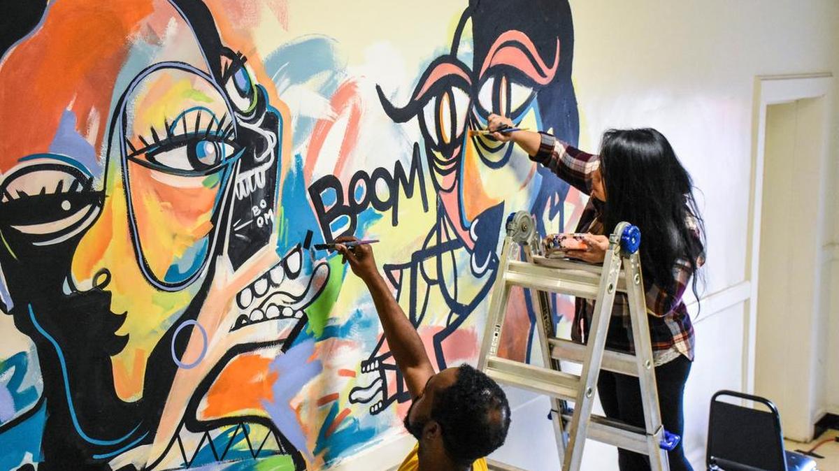 Artists Dammit Wesley and Narly at work on a Nico Amortegui-inspired mural for BOOM.