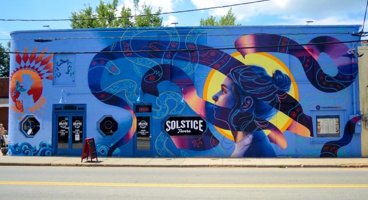 Nicholas Napoletano is a local artist and muralist who brought life to the bare walls of NoDa with his murals. One is painted on the side of Solstice Tavern and the other is a Stella Artois mural on the side of FU Custom Tattoos.