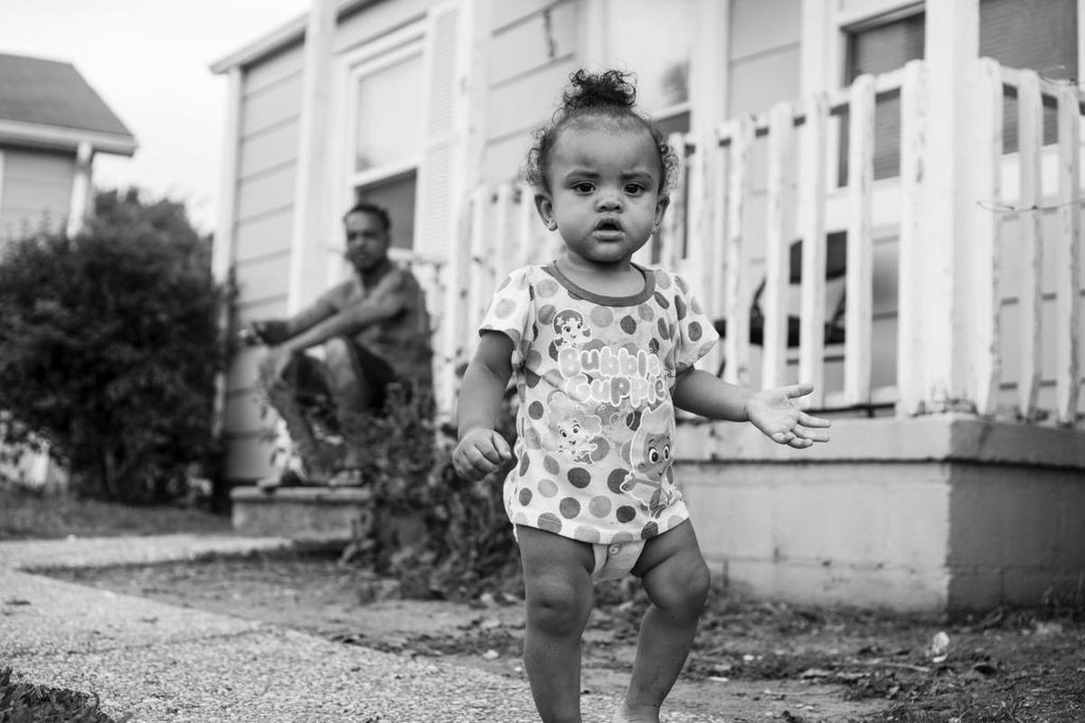 “Step Show.” Van Anthony (in background) and his daughter China – shown here in front of their apartment – are in several photographs in the exhibition. Says Jacobs: “Anytime I was out there, he was with his daughter. They spend all of their time together.” Anthony helped Jacobs navigate Brookhill, he says, and, after asking Anthony’s permission, Jacobs had a birthday party for China (who’d recently turned 1) at the exhibition opening. “Everybody sang to her ... a thousand people.”