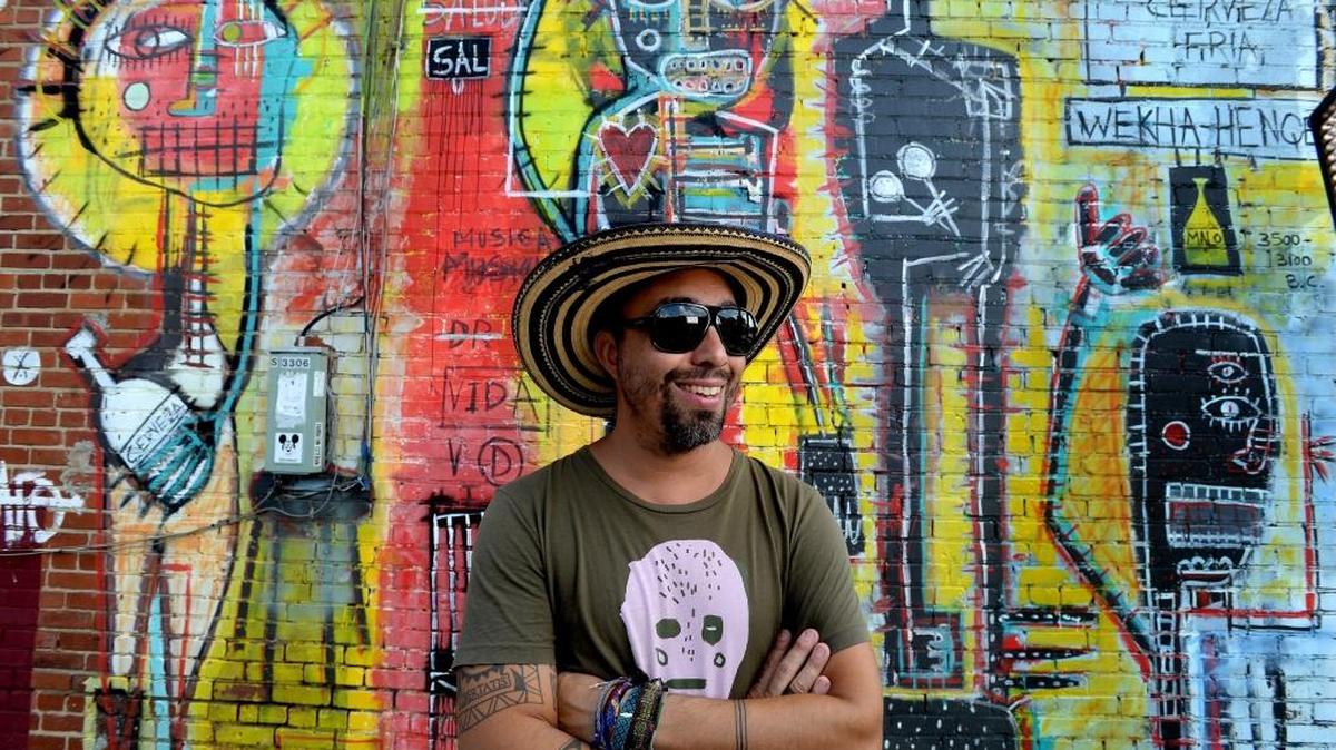 Artist Nico Amortegui with some of his work at Salud in NoDa.