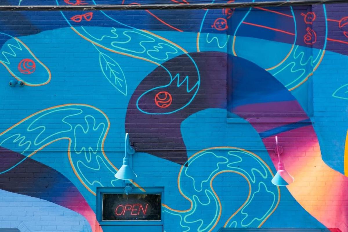 Nicholas Napoletano is a local artist and muralist who brought life to the bare walls of NoDa with his murals. One is painted on the side of Solstice Tavern and the other is a Stella Artois mural on the side of FU Custom Tattoos.