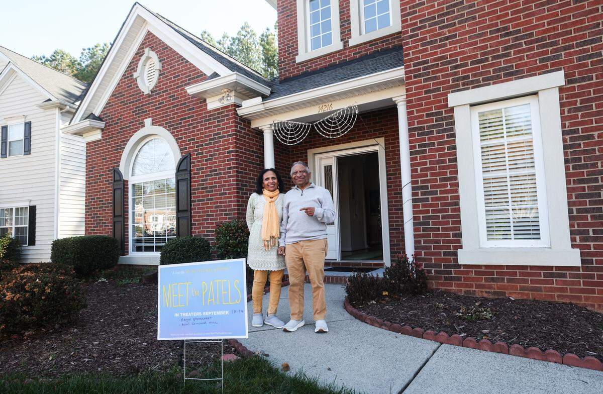 Champa and Vasant Patel stand behind a yard sign for the 2014 film “Meet the Patels” outside their home in Charlotte on Monday, November 24, 2025. The Patels are parents of actor and filmmaker Ravi Patel, and are well-known for their starring roles in “Meet the Patels”, which chronicles Ravi's search for a wife with their help. To celebrate the tenth anniversary of the film, Independent Picture House will host a screening on December 13th. 