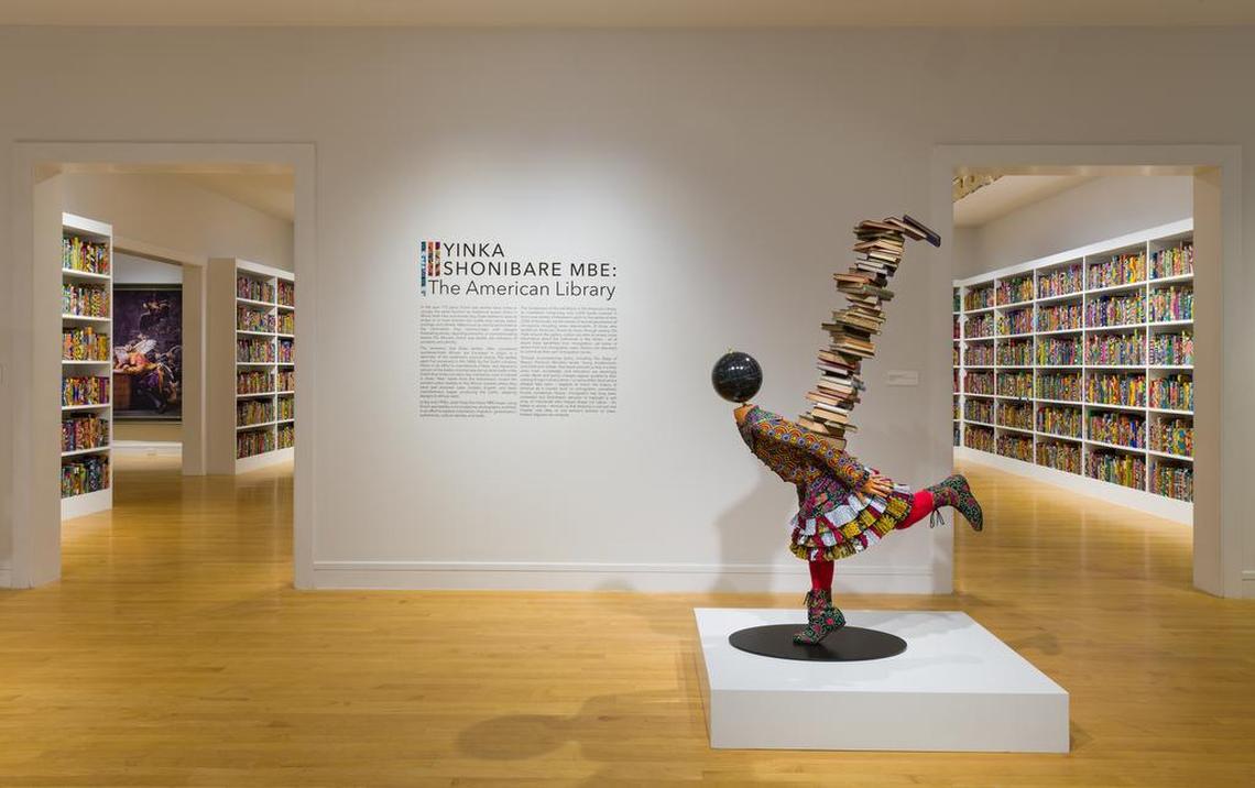 An installation view of “The American Library” by Yinka Shonibare MBE at Davidson’s Van Every/Smith Galleries. (That MBE denotes Most Excellent Order of the British Empire, an honor from the Queen.) Hardback books, Dutch wax printed cotton textile, gold foiled names, interactive application.