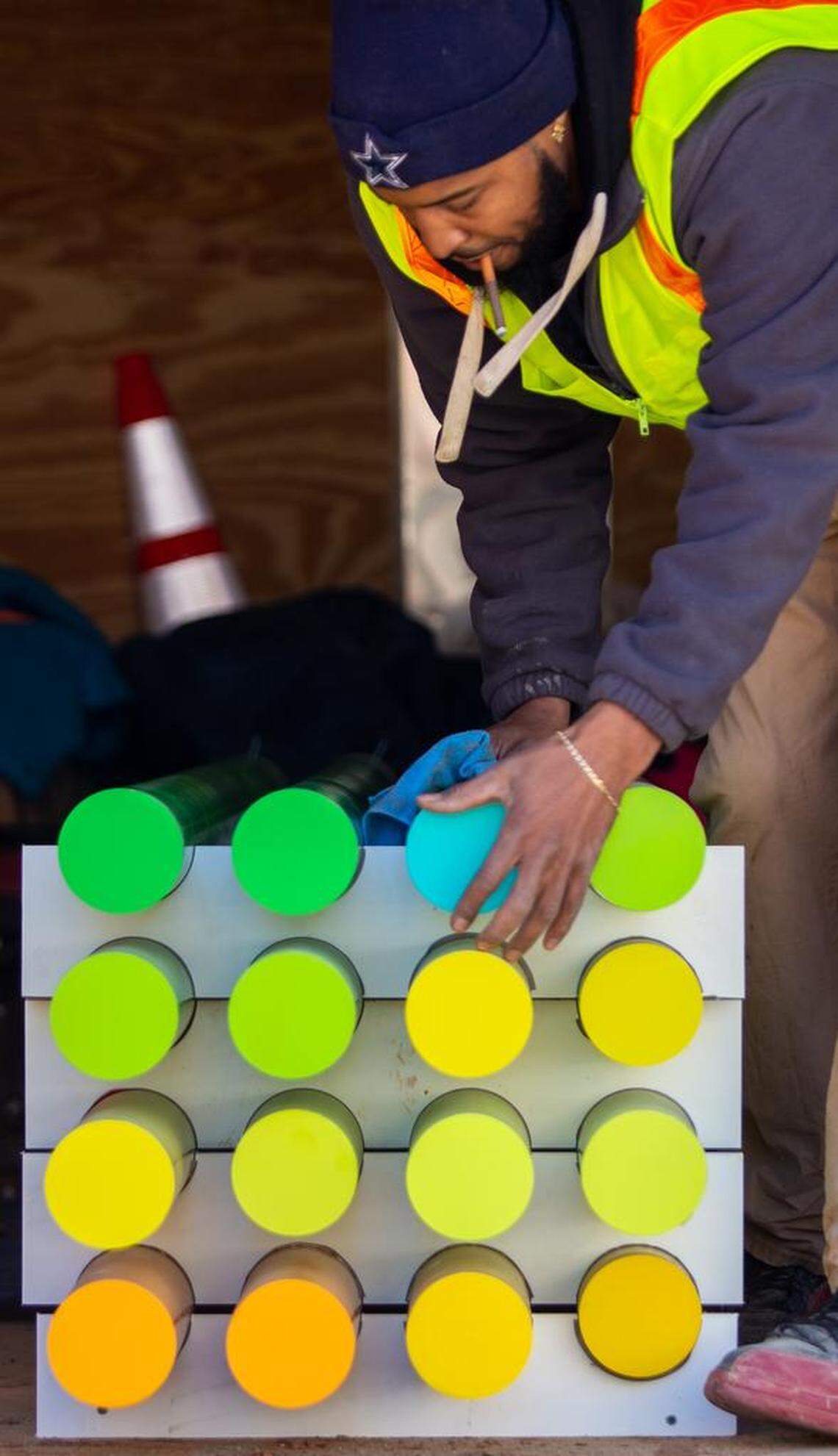 Chris Logan cleans pieces of “The Color Forest” before they’re placed into the ground permanently.