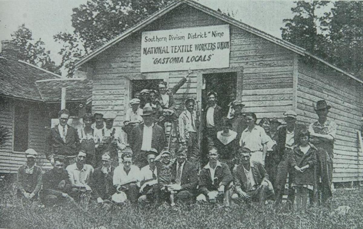 Fred Beal (holding child) with a group of strikers, in a photo from the book “The Story of The Loray Mill Strike Gastonia 1929” by John A. Salmond. Clarence Miller is standing at far left;W. McGinnis,who was also eventually charged with murder, is directly behind Beal.