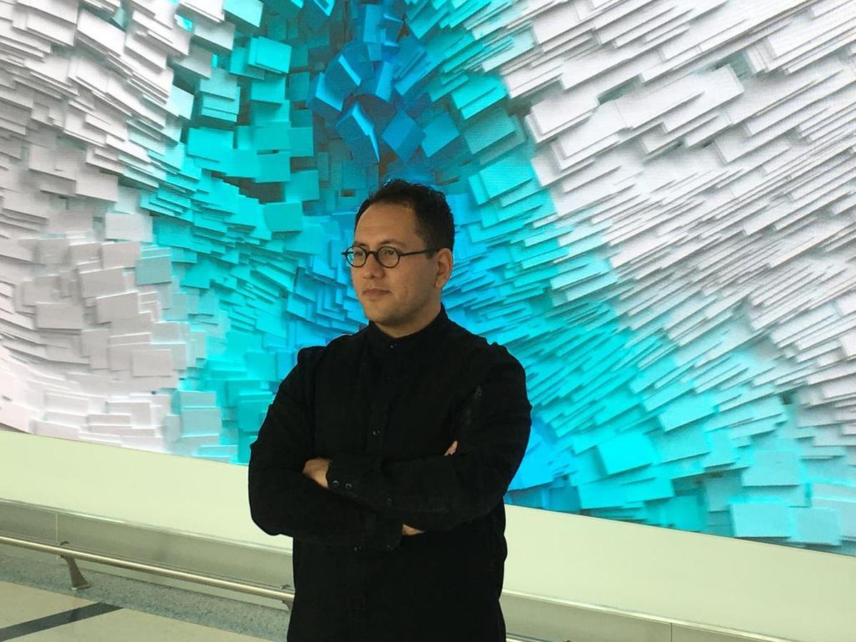Refik Anadol in front of part of his “Interconnected” at the Charlotte airport.