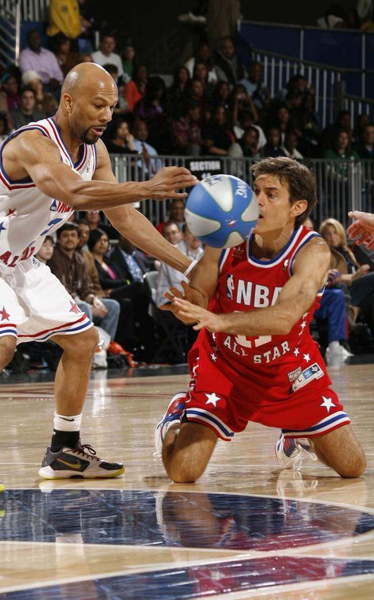 Rapper Common and Mehmet Oz (aka Dr. Oz) dive for the ball during the 2010 NBA All-Star Celebrity Game in Dallas.