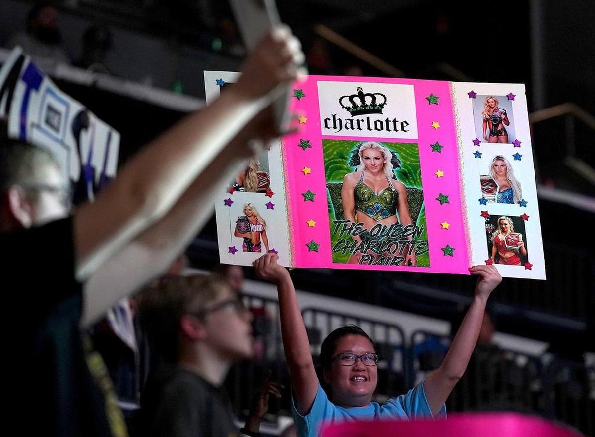 Fans hold up their signs for various wrestlers including Charlotte Flair during WWE’s SmackDown event.
