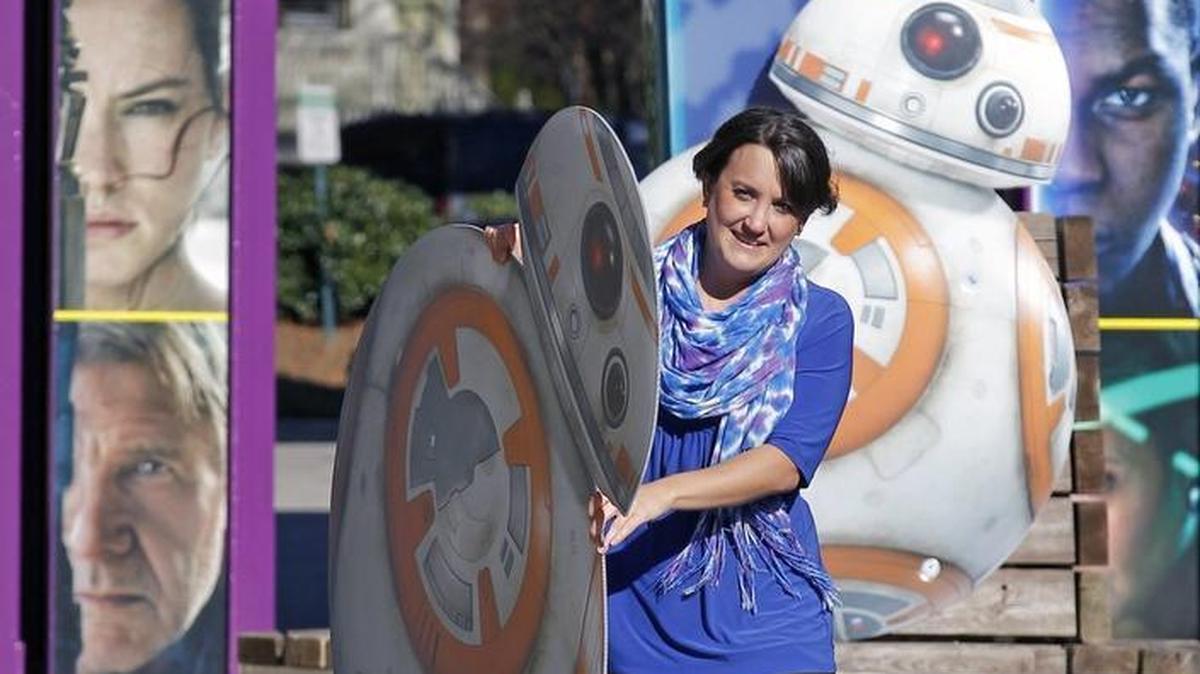 April Lepak carries a display of the droid BB-8 to promote the new Star Wars: The Force Awakens movie at the iMax movie theater at Marbles Kid's Museum in downtown Raleigh on Wednesday.