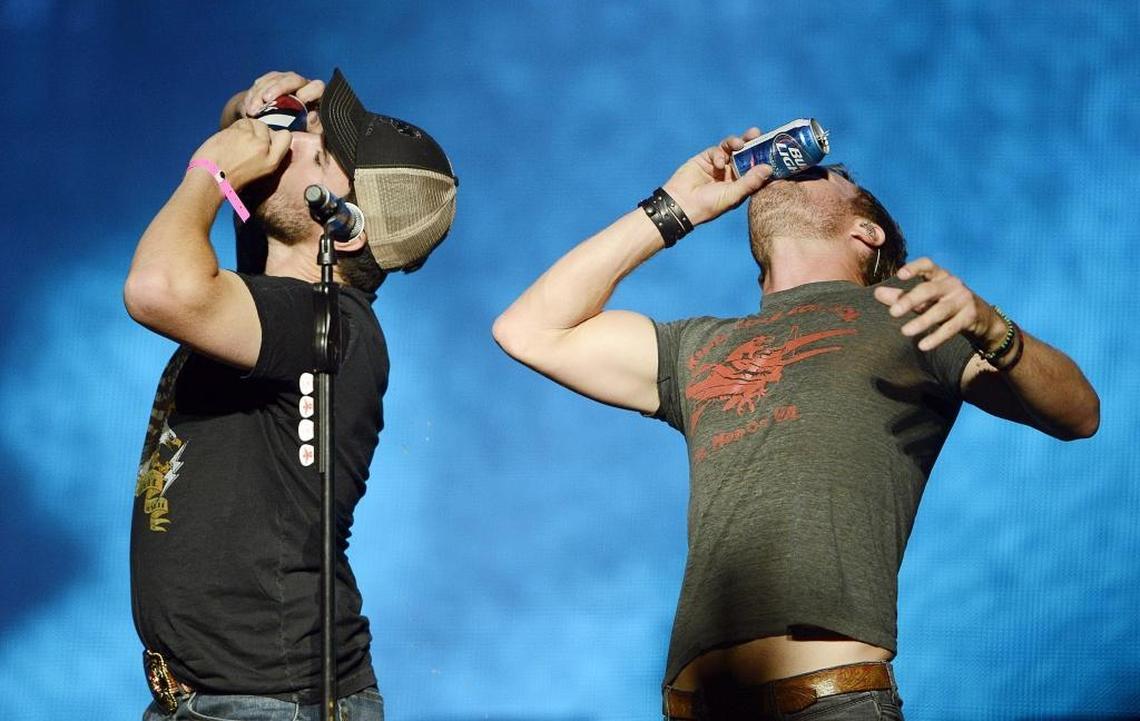 Dierks Bentley, right, shot-guns a beer with a fan while performing at the Save Mart Center in Fresno, Calif., on Aug. 20, 2015.