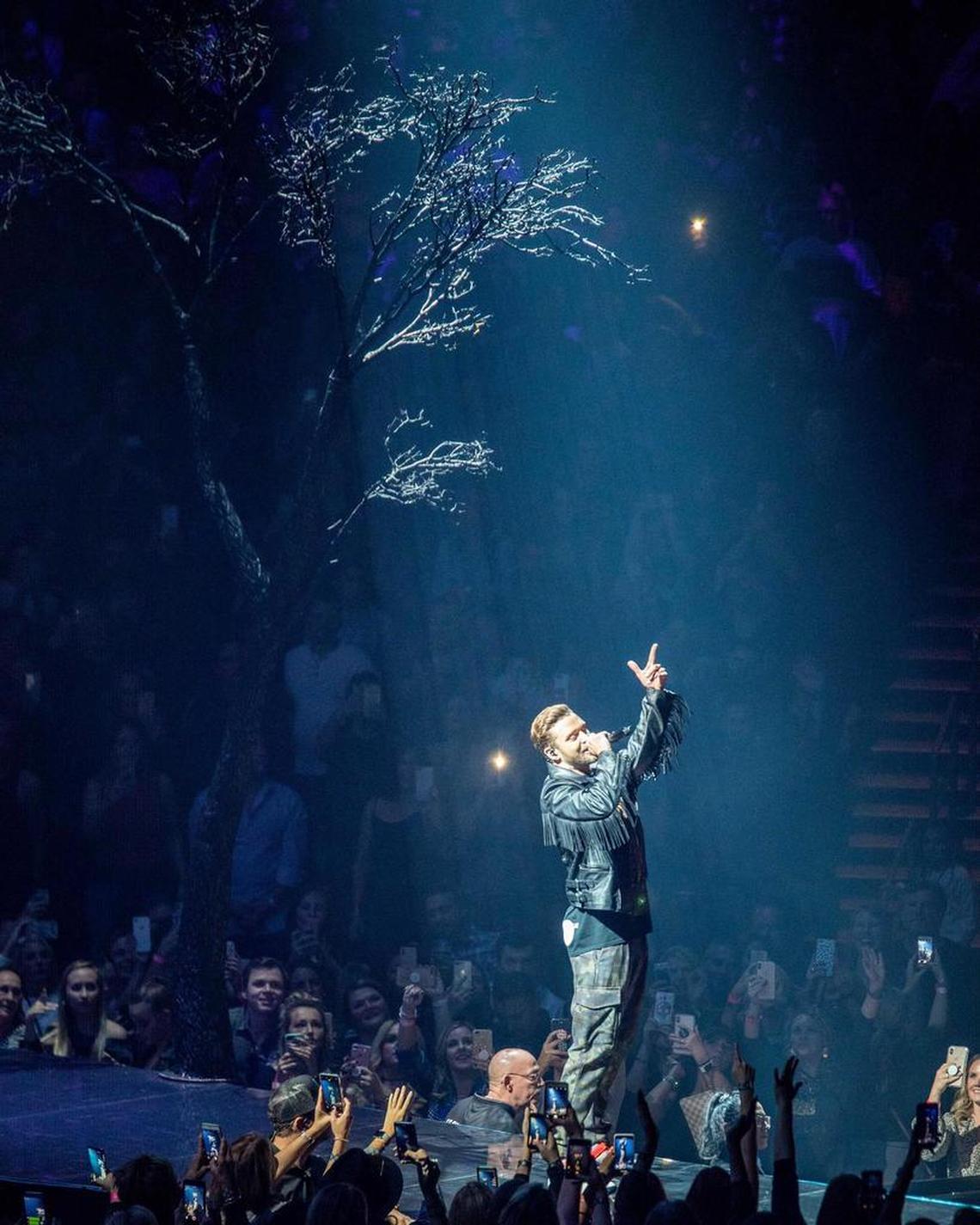 Justin Timberlake performs in the shadow of a big fake tree on stage at Spectrum Center.