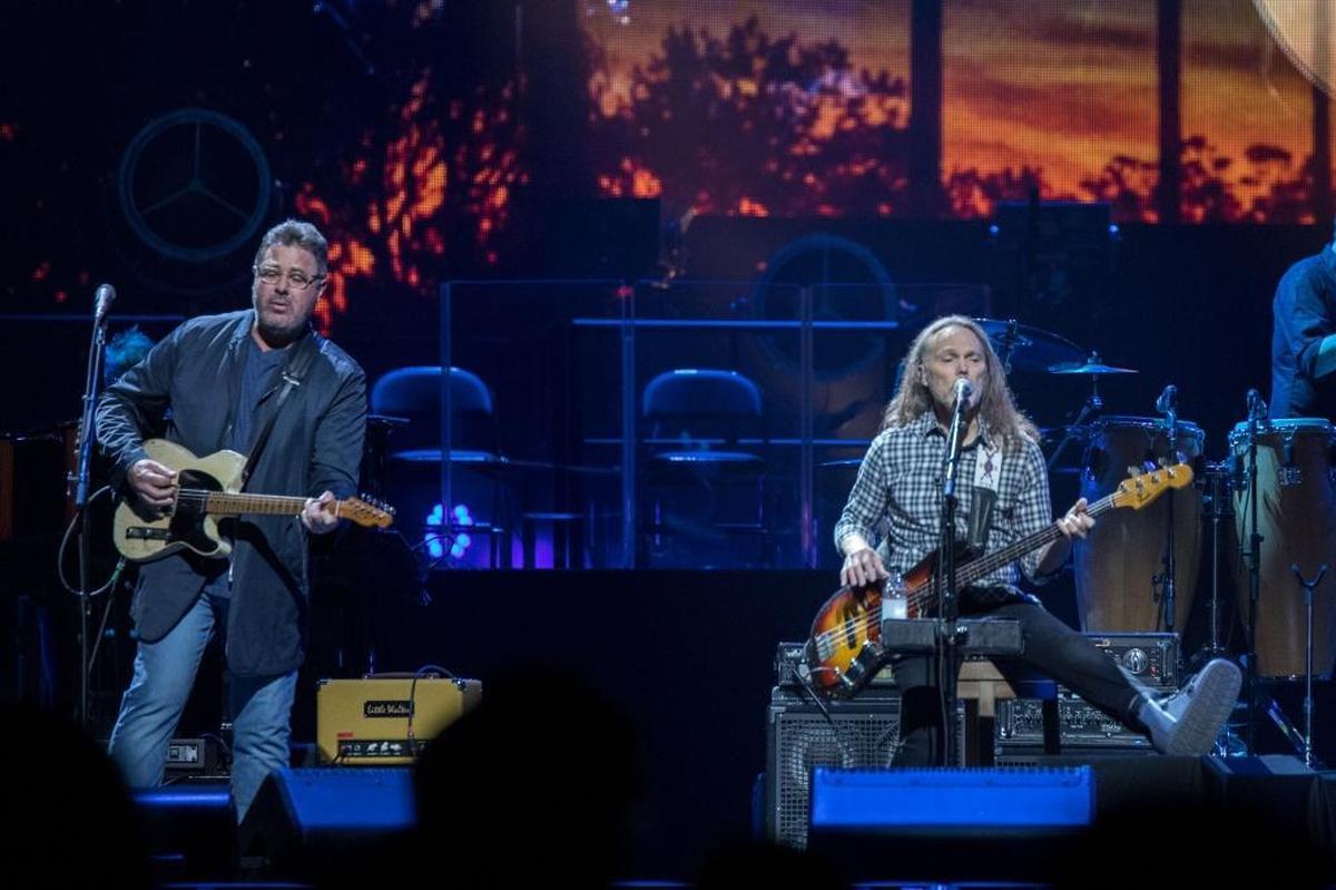 Vince Gill and Timothy B. Schmit perform during the Eagles’ show at Spectrum Center on Wednesday night. Schmit is recovering from a leg injury he sustained after falling in the shower when the band was in Chicago.