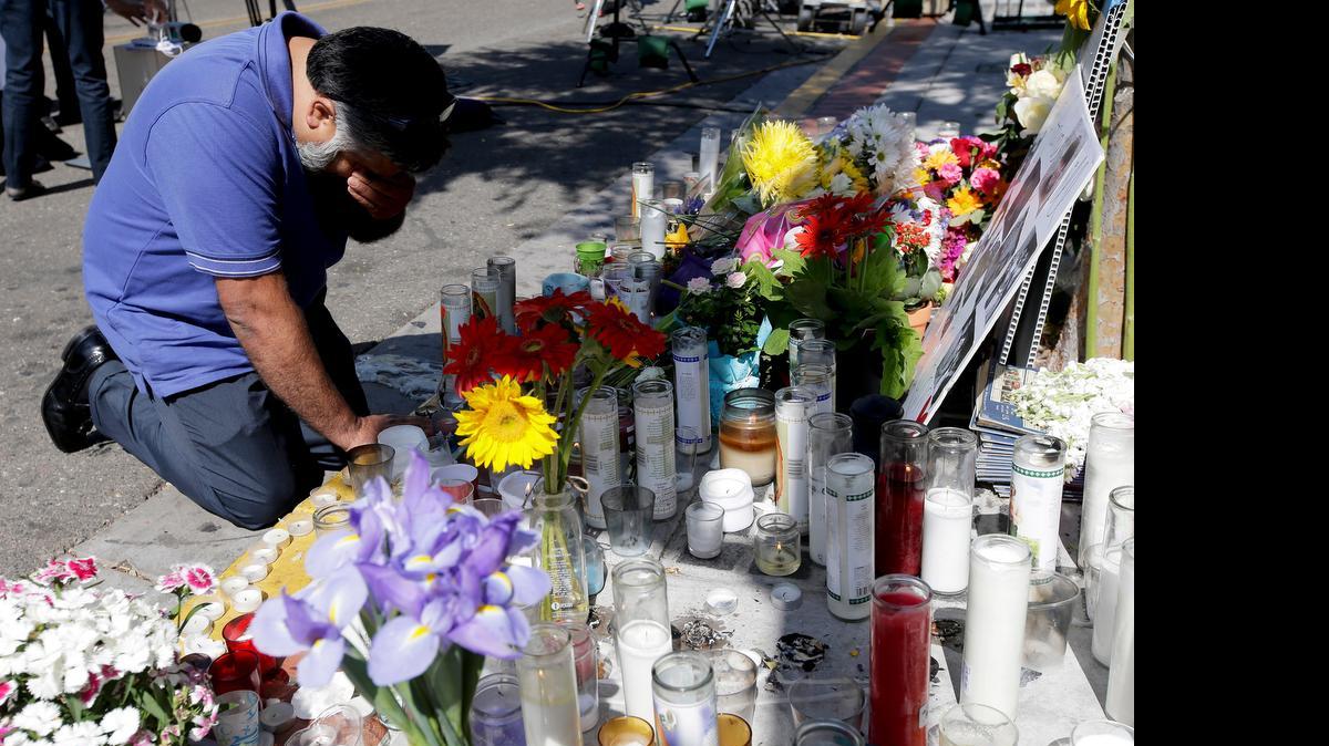 
Jose Cardoso pays his respects at a makeshift memorial in the Isla Vista area near Goleta, Calif., where part of a mass shooting took place on May 25, 2014. Sheriff's officials said Elliot Rodger, 22, went on a rampage near the University of California, Santa Barbara, stabbing three people to death at his apartment before shooting and killing three more in a crime spree through a nearby neighborhood. 
