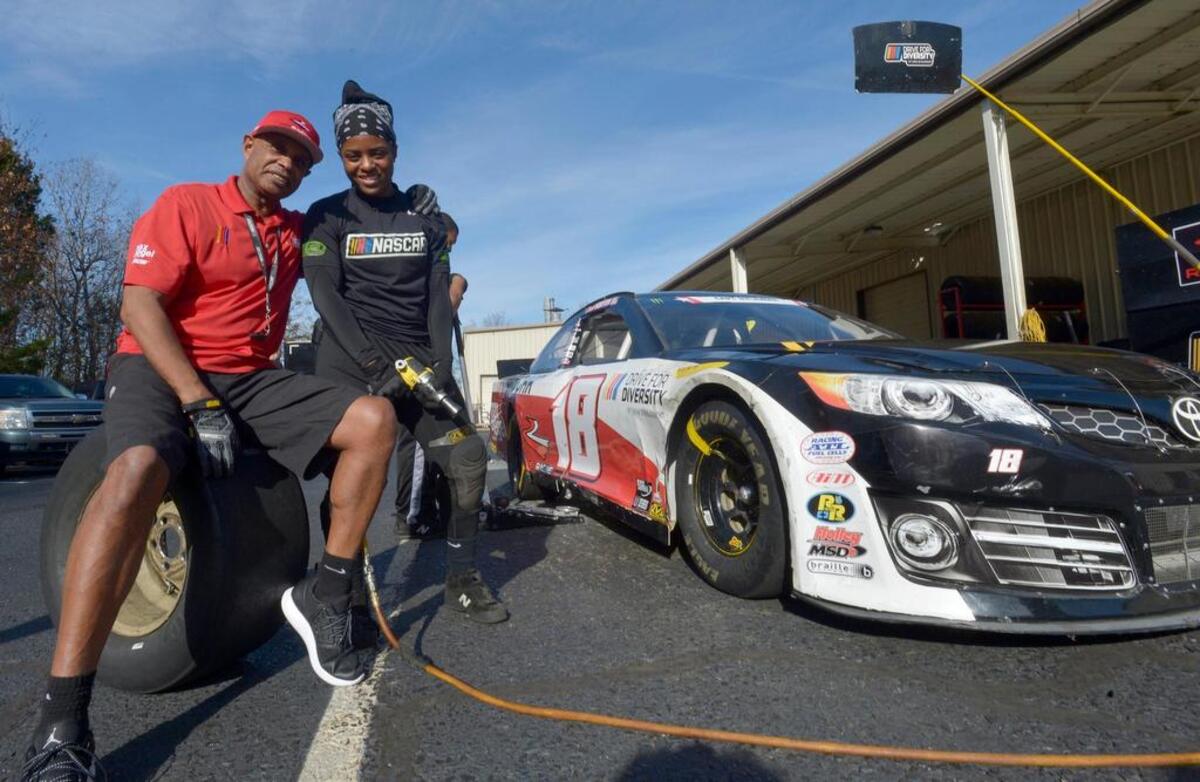 Drive for Diversity pit crew coach Phil Horton poses with Brehanna Daniels in the practice area at Rev Racing in Concord.