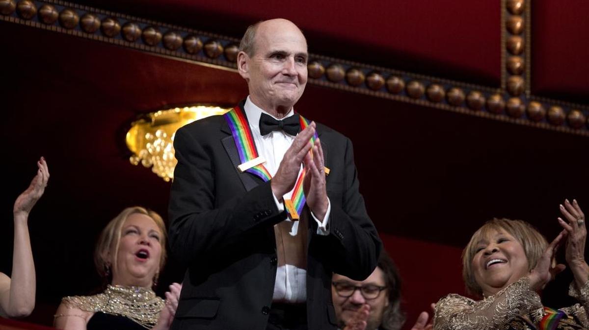 Recipient of the 2016 Kennedy Center Honor award, musician James Taylor, acknowledges the applause during the Kennedy Center Honors gala at the Kennedy Center in Washington, Sunday, Dec. 4, 2016. On the right is honoree gospel and blues singer Mavis Staples.