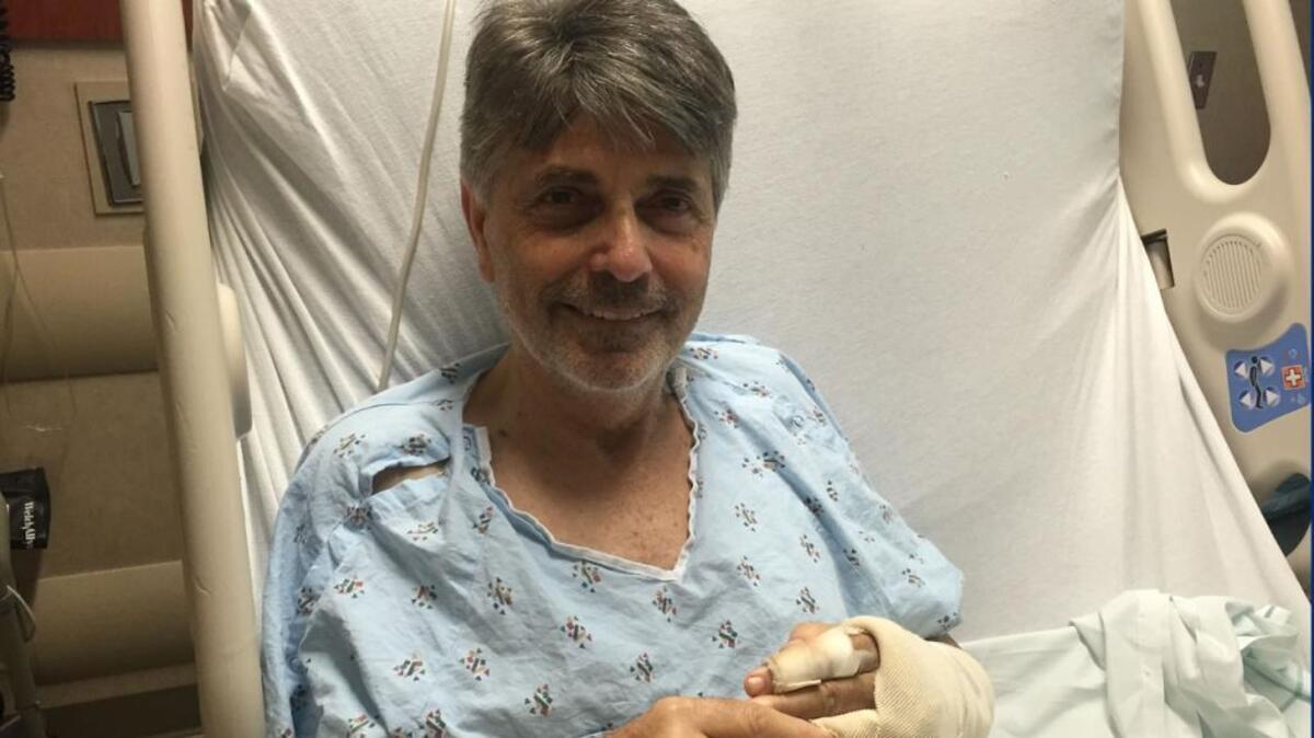 Sporting a week’s growth of beard, WCNC forecaster Larry Sprinkle recovers Thursday in his hospital bed.