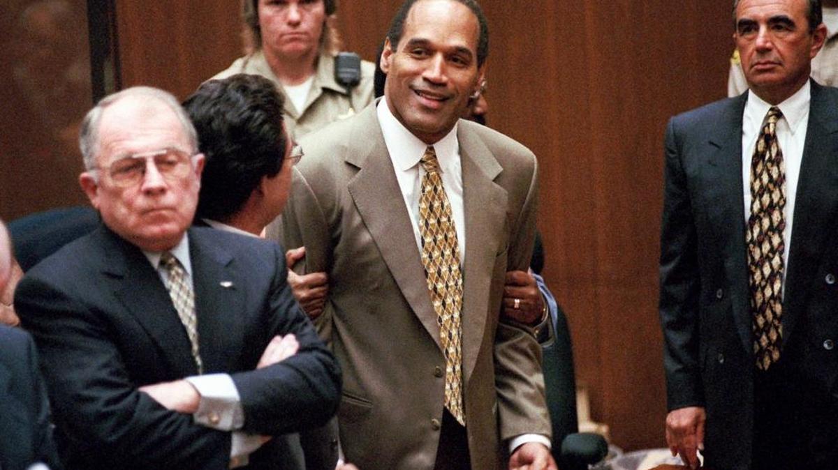 O.J. Simpson, center, clenches his fists in victory after the jury said he was not guilty in the murders of his ex-wife Nicole Brown Simpson and her friend Ronald Goldman in a Los Angeles courtroom. Attorneys F. Lee Bailey, left, and Robert Shapiro, right, look on.