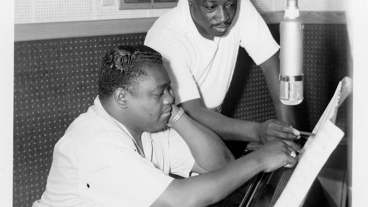 Fats Domino (seated) and Dave Bartholomew, producer/songwriter/bandleader and longtime collaborator, who co-wrote and produced most of Fats’ hits, at piano.