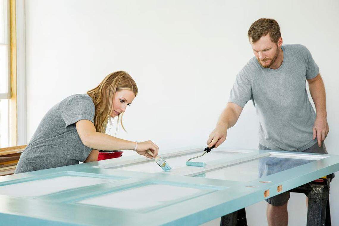 NASCAR star Dale Earnhardt Jr. and his wife wife Amy paint the front bedroom door.