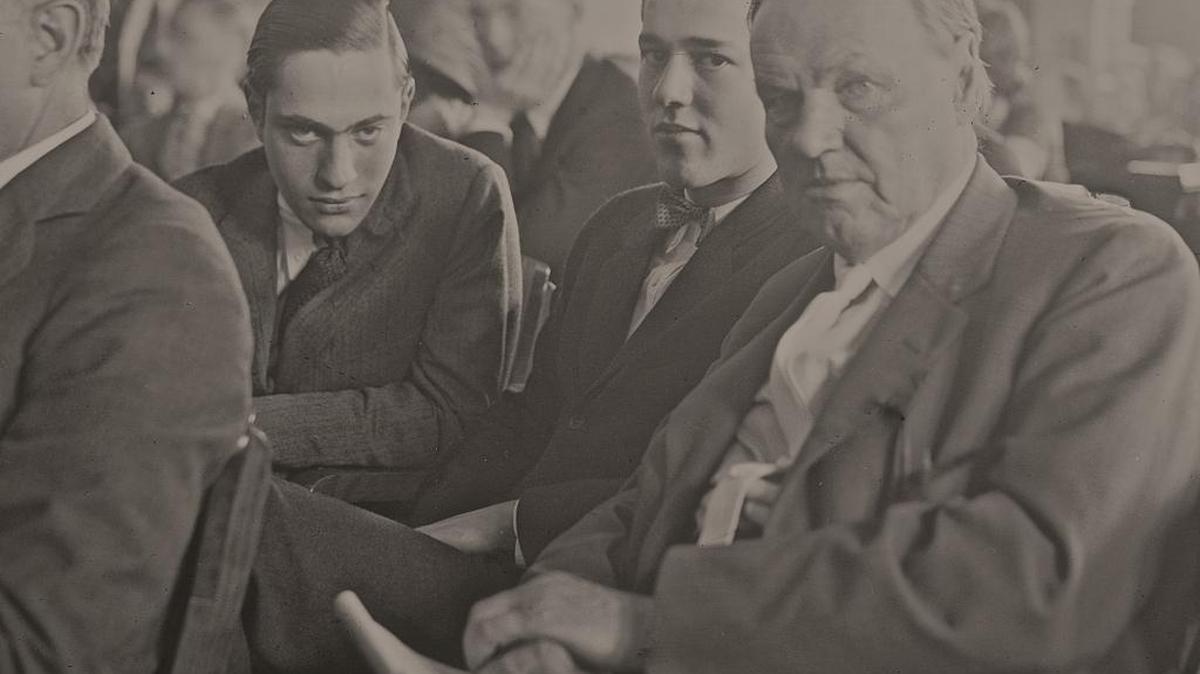 Richard Loeb (left), Nathan Leopold, Jr. (center) and defense attorney Clarence Darrow in a crowded courtroom in Chicago, Illinois, during the Leopold and Loeb murder trial, July 24, 1924. Benjamin Bachrach, defense attorney, is seated in front of Darrow.