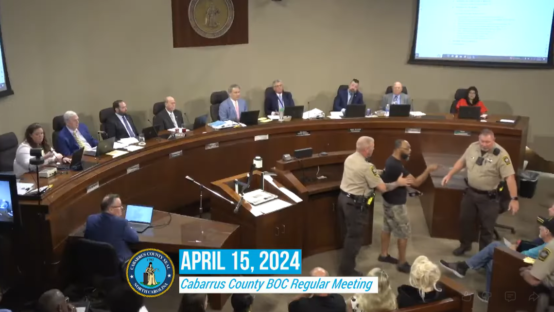 James Campbell is escorted out of a April 15, 2024, Cabarrus County commission meeting after he addressed members of the commission by name. The county agreed to settle with Campbell. James Campbell is escorted out of a April 15, 2024, Cabarrus County commission meeting after he addressed members of the commission by name. The county agreed to settle with Campbell.