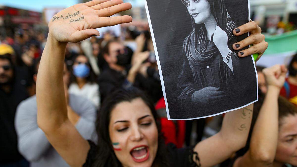 A woman in Istanbul, Turkey holds up a drawing of Mahsa Amini during an Oct. 2, 2022 protest against Amini’s death in Iran. Thousands of Iranians have taken to the streets in recent weeks to protest after Amini, 22, died while detained by Iran’s morality police for allegedly not adhering to Iran’s strict Islamic dress code. Her death has sparked protests across the globe.