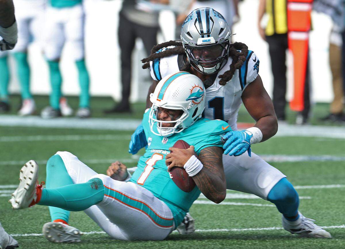 Carolina Panthers linebacker Pat Jones, right, sacks Miami Dolphins quarterback Tua Tagovailoa, left, during action on Sunday, October 5, 2025 at Bank of America Stadium in Charlotte, NC. The Panthers defeated the Dolphins 27-24.