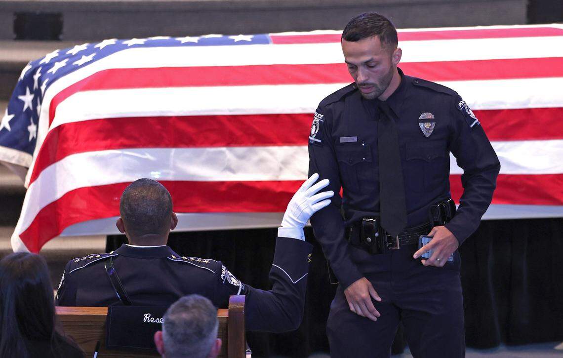 CMPD Chief Johnny Jennings, left, touches the arm of officer Nicholas Ferreira, right, after Ferreira shared memories of fallen CMPD Officer Joshua Eyer on Friday, May 3, 2024 at First Baptist Church in Charlotte, NC. CMPD Officer Joshua Eyer and three other law enforcement officers died on Monday, April 29, 2024 during and as a result of a standoff with a gunman.