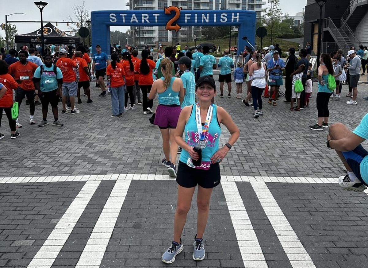Sue Glass, photographed at the finish line for the 2024 Run! Ballantyne race. The annual 8K/5K event is part of the YMCA’s signature race series and supports the organization’s youth development, healthy living, and community well-being programs across the Charlotte region.
