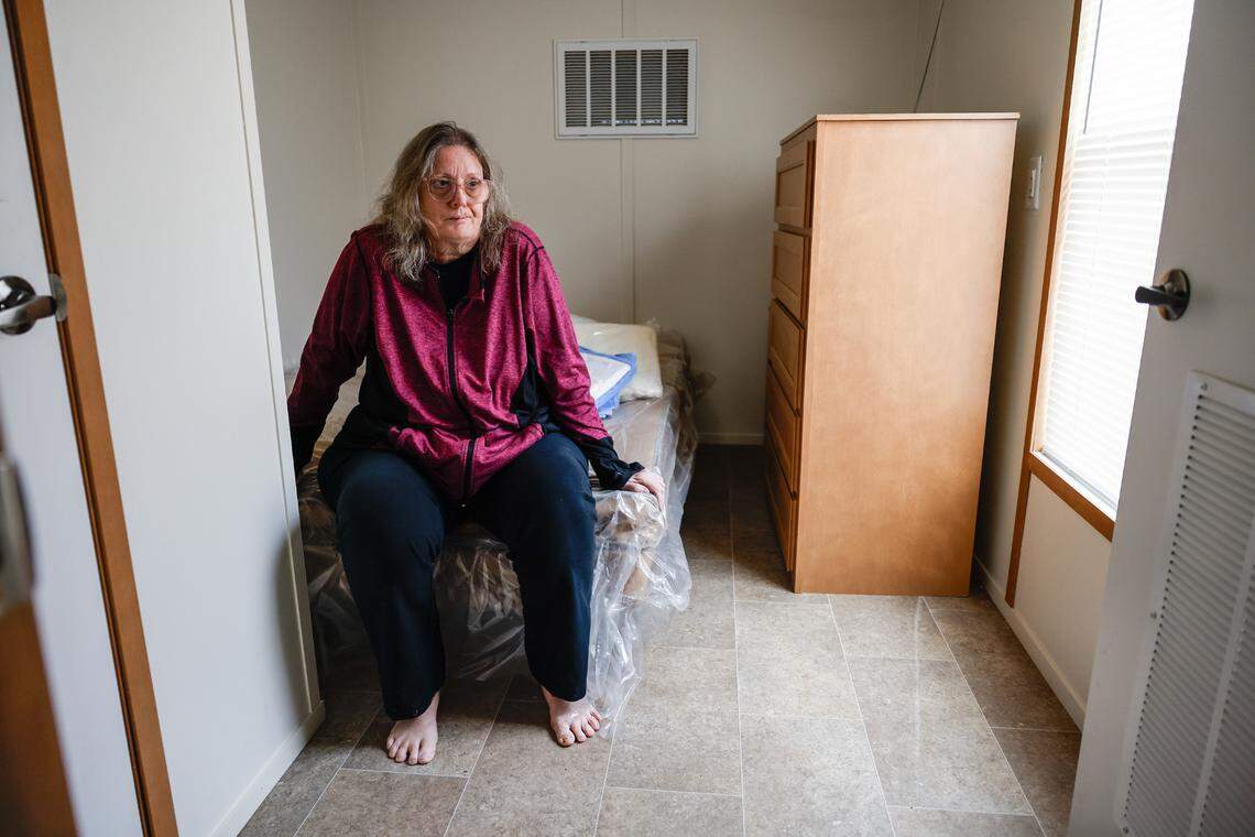 Karen Schmid sits on a new mattress in a FEMA-provided trailer in Black Mountain in January. After Helene, Schmid stayed in hotel rooms in Charlotte, Marion and Asheville, with FEMA covering the cost through its Transitional Sheltering Assistance program.
