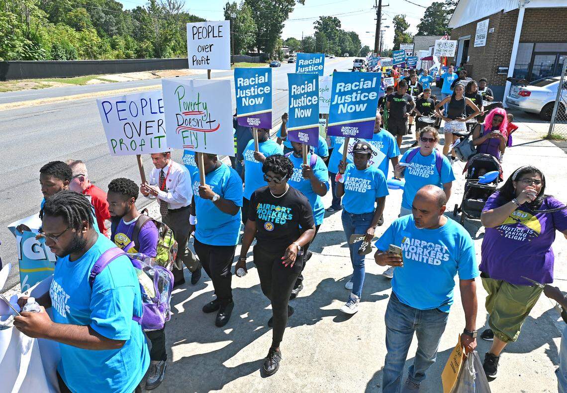 Hundreds of people marched Tuesday on Wilkinson Boulevard near Charlotte Douglas International Airport demanding a living wage, better working conditions and benefits to be included in the FAA Regulation bill.