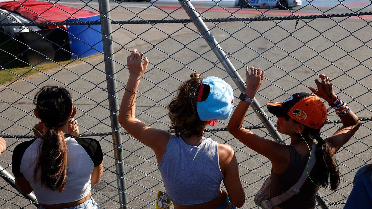 NASCAR fans line a fence line as drivers compete in the Bank of America Roval 400 at Charlotte Motor Speedway in Concord, NC on Sunday, October 13, 2024.