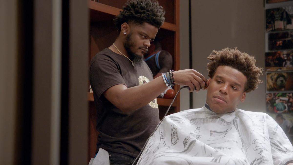 In a scene from “All or Nothing,” quarterback Cam Newton gets a haircut in his home while discussing the 2018 season.