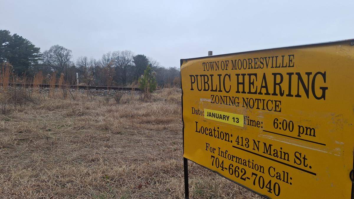 A Virginia builder plans 218 townhomes near a major connector highway under construction near Lake Norman. This sign announced a public hearing on the project.